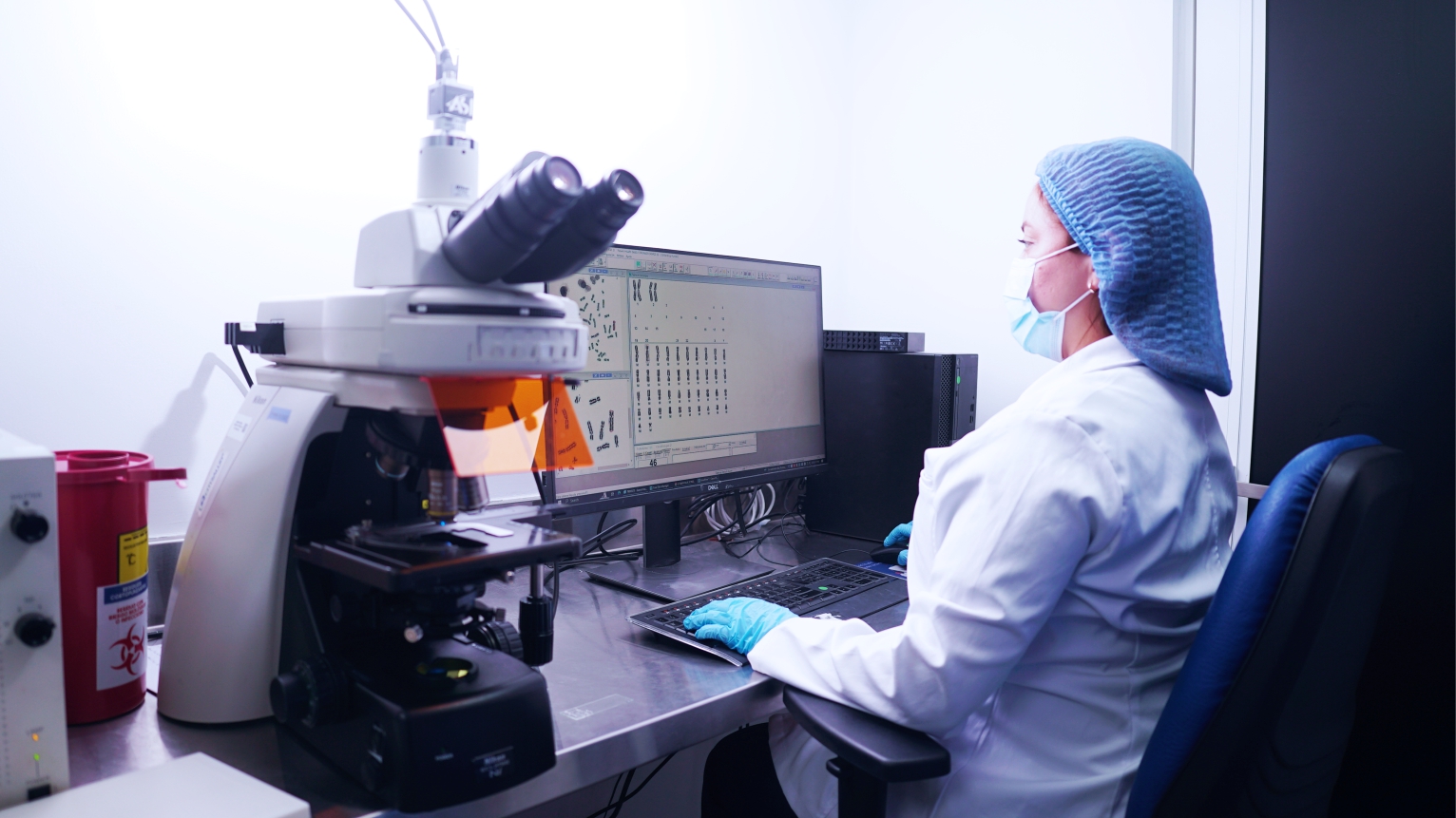 Profesional Citisalud analizando muestras en microscopio y monitor